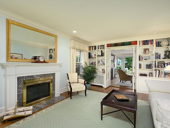 The custom French doors, flanked by built-in bookshelves, lead you into the family room, patio, sunr