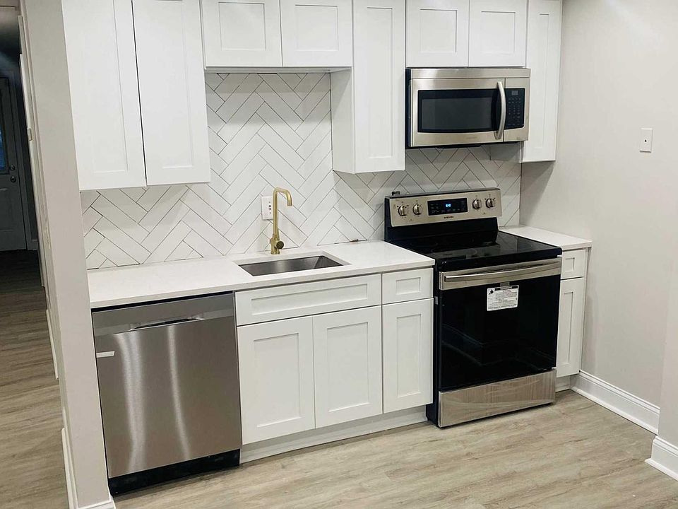 Main kitchen with herringbone backsplash and quartz countertop. Brand new appliances.