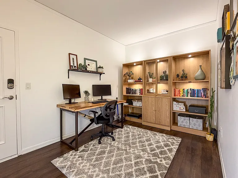 Beautiful built in shelving in large office/ den. Desk and monitor setup perfect for a working professional.