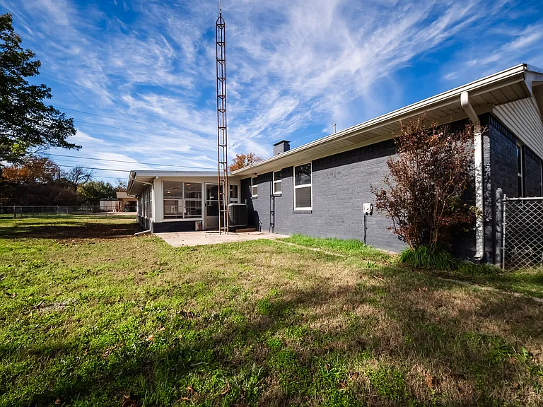 Side view of the home showing the extended layout and blue exterior