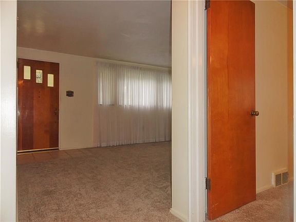 The 12" ceramic tile entry leads to either the upstairs, the dining room or shown here the living room.  The window treatments A