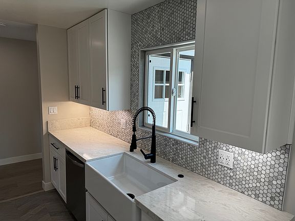 Kitchen fully remodeled with quartz tops, tiled backsplash from countertop to ceiling, undercabinet lighting, farm fireclay sink, disposal air switch, soft close cabinets and drawers.