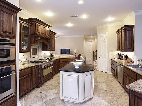 A beautiful wood paneled fridge & a great over-sized island kitchen is what you'll find here! HUGE breakfast bar & dark wood cabinets! This kitchen is the heart of the house for a reason!