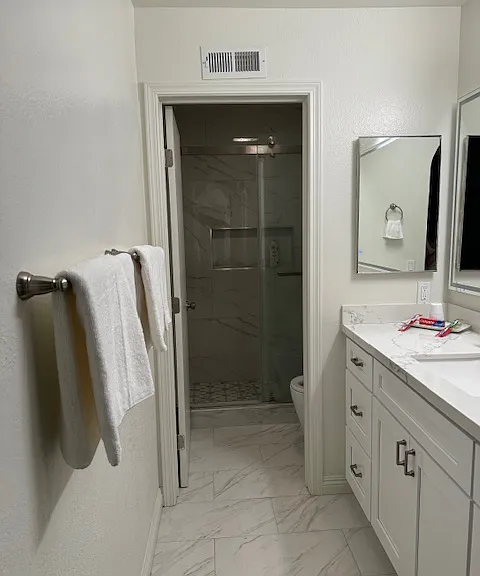 Newly renovated in suite bathroom with Calacatta River quartz counter and wall to wall ceramic tile wall,LED vanity mirror, and Bidet.