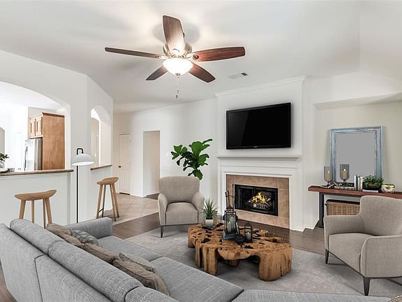 Spacious Living Room is open to Kitchen and features gas log fireplace and wood-like tile floors. Entire interior freshly painted white for a neutral palette and makes the home feel light and bright! PHOTO VIRTUALLY STAGED.