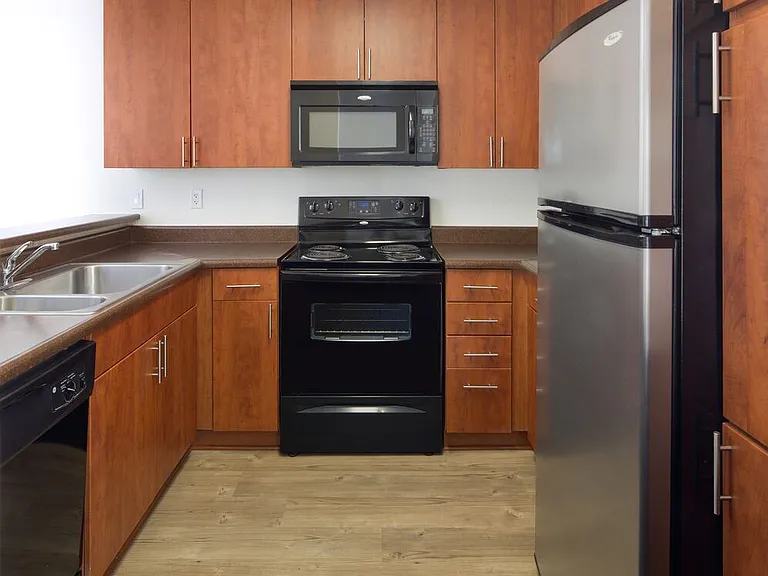 Classic Package I kitchen with black appliances, cherry cabinetry, laminate countertops, and hard-surface flooring