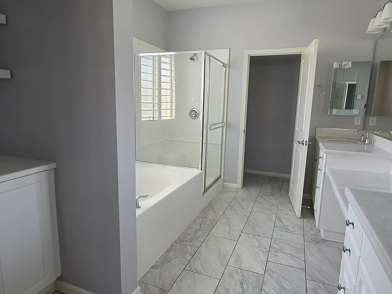 Master bath with storage, dual vanities, soak-in tub, shower, and private WC