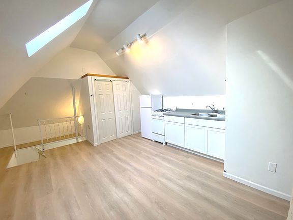 Unit 3 good sized kitchen area with large panty beyond and skylight above.