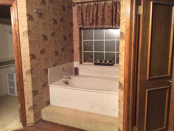 master bath with jetted tub and 2 walk in closets