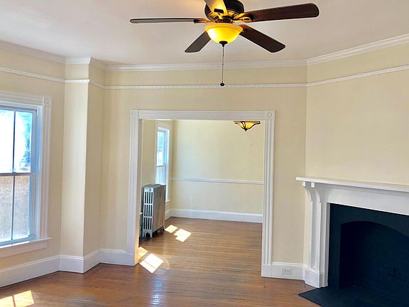 Spacious living & dinning room set up with tall ceilings flooded with natural light. Tall ceilings and decorative mantel.