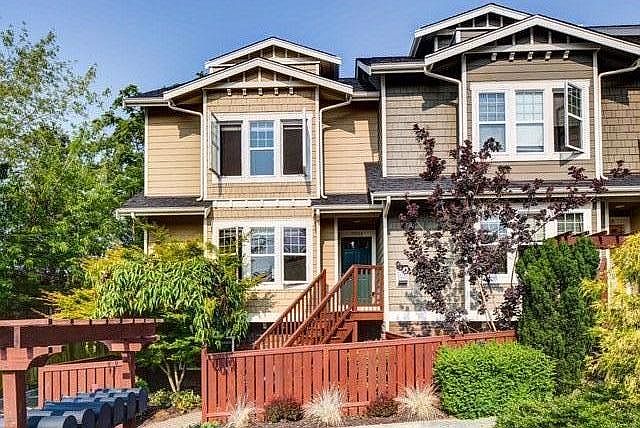 newer corner townhome with attached 2 car garage( in the back) and a maintenance free front yard only. Front entry door is on the second floor via the stairs in the front yard as seen on this photo. Access is also available from inside the garage on the