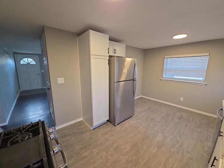 Bright kitchen with updated countertops, white cabinetry, stainless refrigerator and range, and dishwasher.