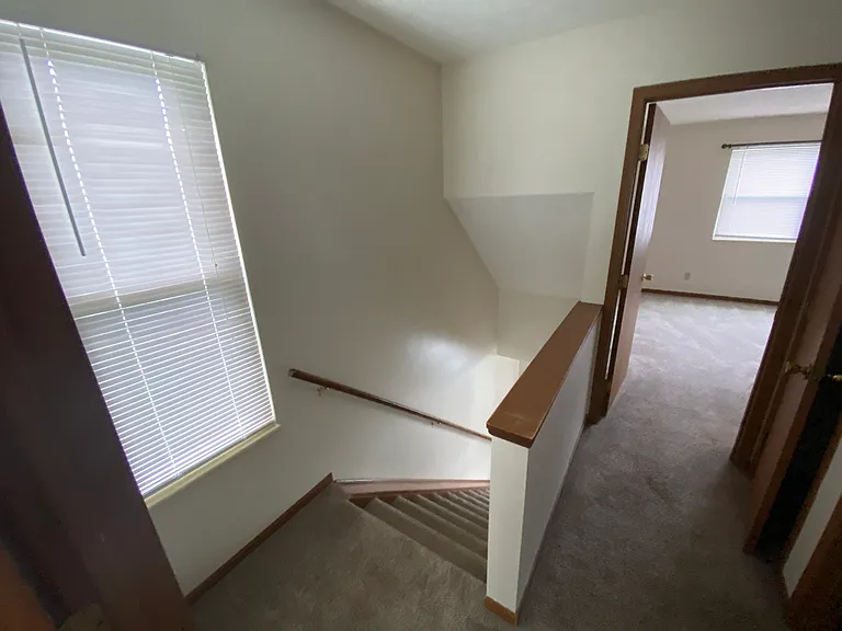 Second story hallway looking downstairs and second bedroom