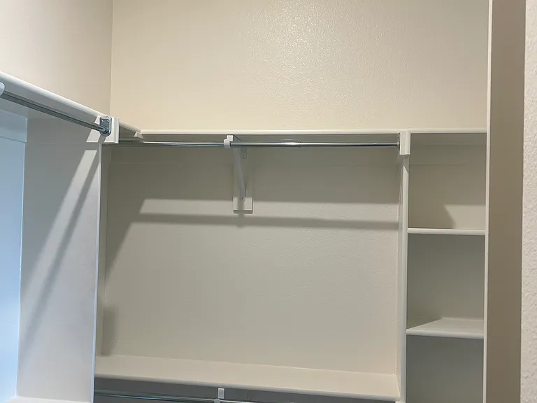 Spacious walk-in closet with custom built in shelves.