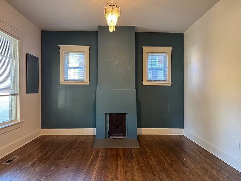 Living room. Fireplace is non-functional. Original cast iron cover still in place.