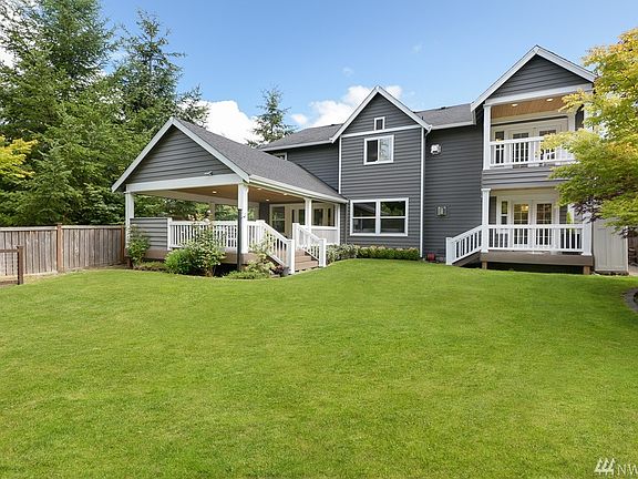 Lush grounds with mature plants and fully fenced yard.
