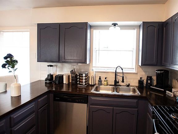 Kitchen with decorative backsplash, sink, range with gas cooktop, and stainless steel dishwasher.