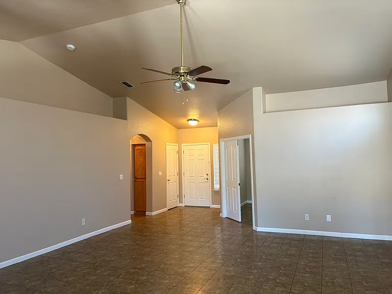 Family room with view to office, front door and hallway that leads to bedrooms and baths