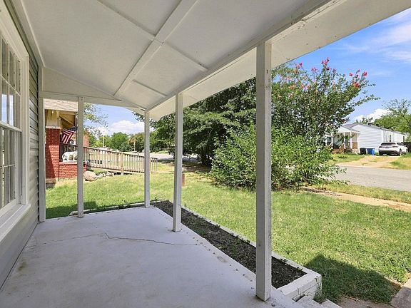Covered concrete porch with white support posts