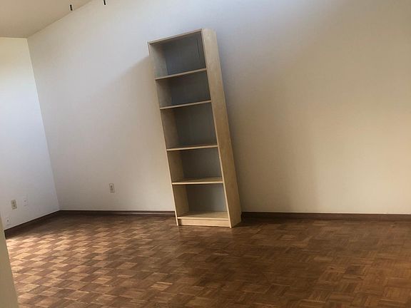 Living area adjacent to kitchen, hardwood flooring, sliding door to patio