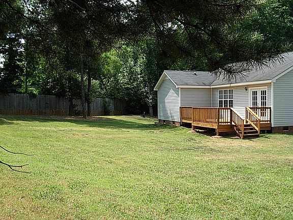 Rear view of 1/2 acre lot with huge new party deck and 6 ft. privacy fence!