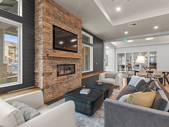 The Modera Lacey resident clubhouse with a modern fireplace and lounge seating is where modern elegance meets cozy warmth.