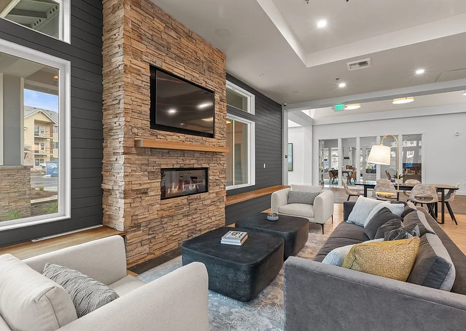 The Modera Lacey resident clubhouse with a modern fireplace and lounge seating is where modern elegance meets cozy warmth.