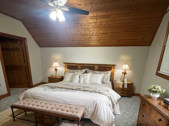large bedroom with original brick, high vaulted ceilings, LED lighting & upgraded fixtures, ceiling fan, built-in shelves, study, custom cabinets, vanity, walk-in closet, full bathroom with plenty of storage space.