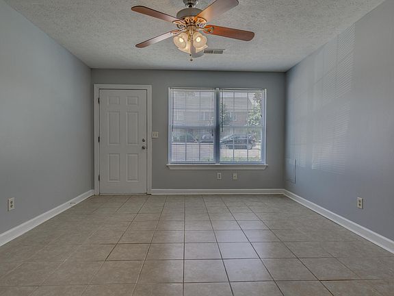 2 bedroom flat living room, tile flooring, ceiling fan.