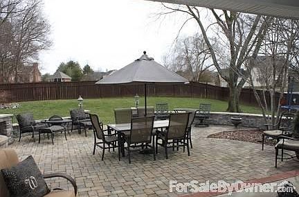 custom stone patio with fenced back yard