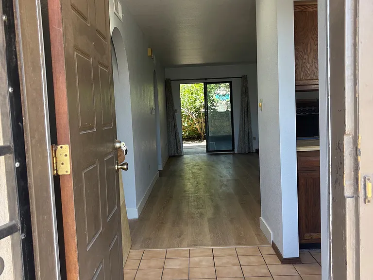 Front entrance to living with kitchen on right side