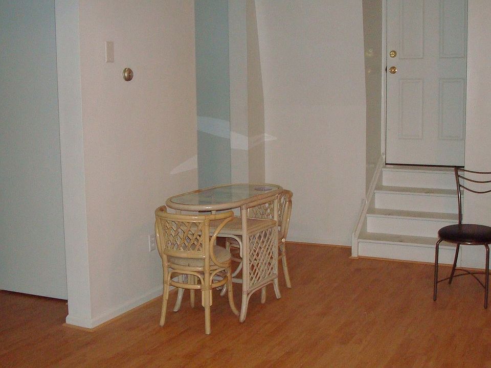Living room from kitchen view. Entry door to the apartment is to the left back left is laundry area, including stack washer and dryer.
