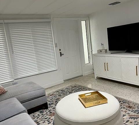 The door is the entry way to our baby bungalow and this room has a terrazzo floor covered with a rug.