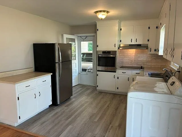 New granite countertops with tile backsplash, new stove top and LVP flooring.