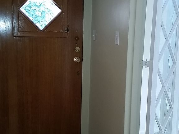 Entry Foyer and to the right, diamond-paned bi-fold privacy doors to the Living Room