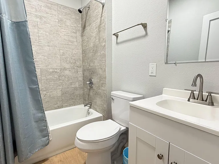 Updated full bath with tiled tub/shower surround, single-sink vanity, and mirrored medicine cabinet for everyday convenience.