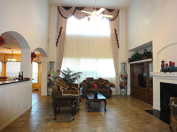 Very spacious family with hi-ceiling, tile floor and gorgeous custom drape, fire place and entertainment niche