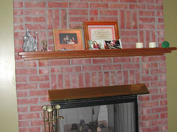 Brick fireplace with wood mantle