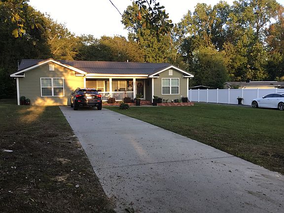 Front of home, nice front porch with bricked in floral beds