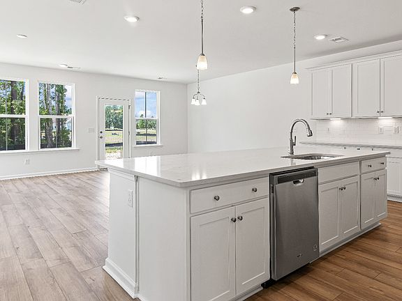 Open concept kitchen with generous island for hosting in the Heron townhome plan by DRB Homes