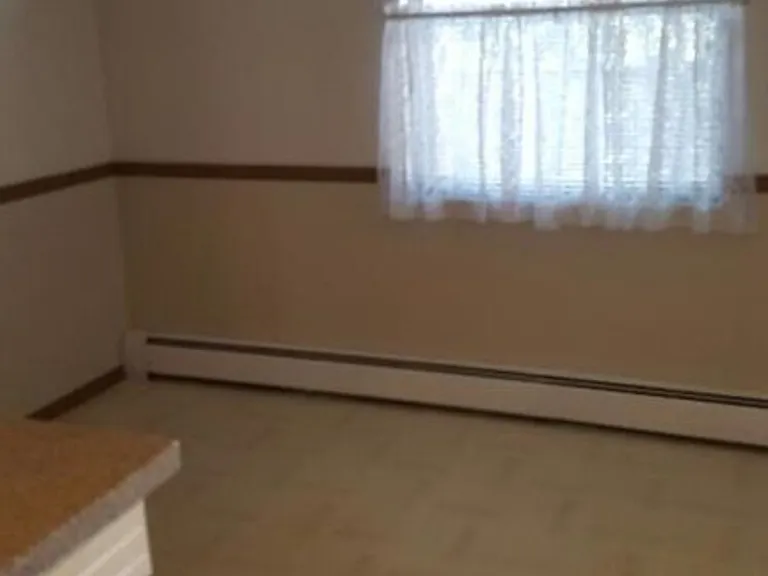 Galley kitchen with eat-in breakfast nook area and window out to courtyard.