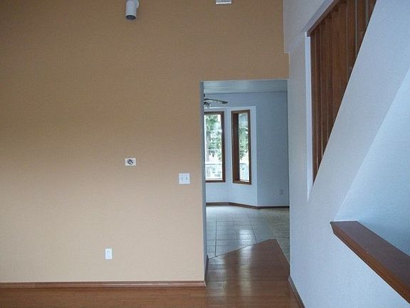 Living room as seen from entry, looking ahead at bay window for kitchen eating area