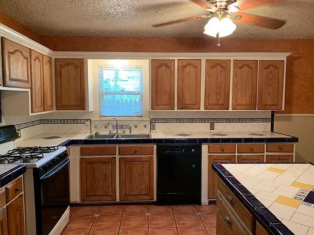 Large kitchen with designer tile and saltillo tile floor. Lots and lots of cabinets and drawers for storage