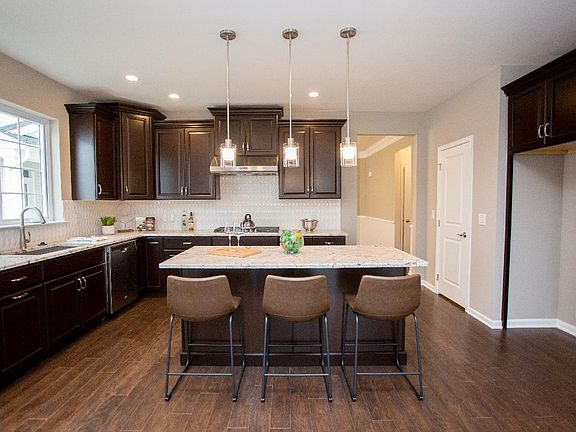 The stunning kitchen boasts a designer backsplash, modern cabinets and upgraded countertops