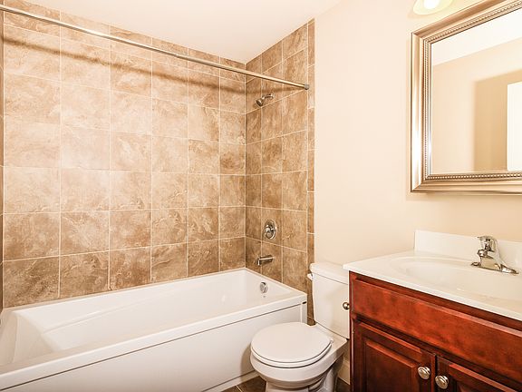 Six foot bathtubs with tiled walls.