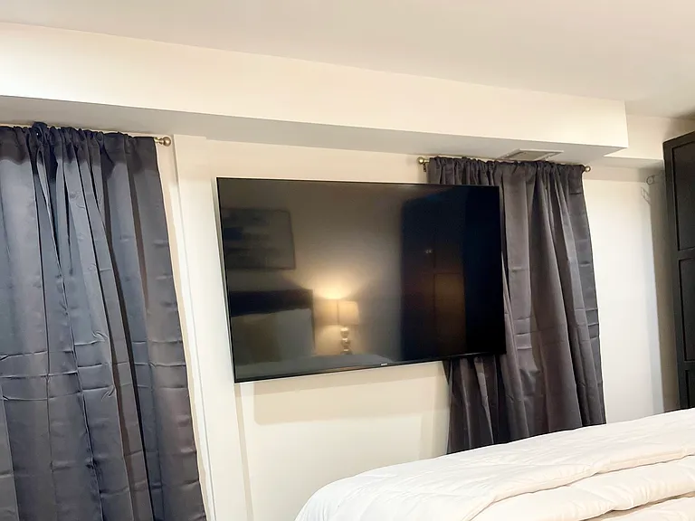 Apartment Bedroom with 65 inch TV and king size bed