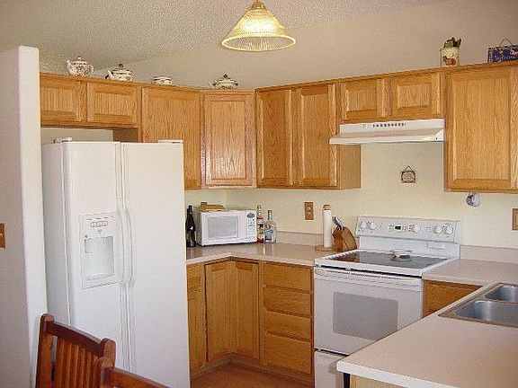 Open Kitchen with smooth-top self-cleaning range/oven, refrigerator and Pergo flooring.