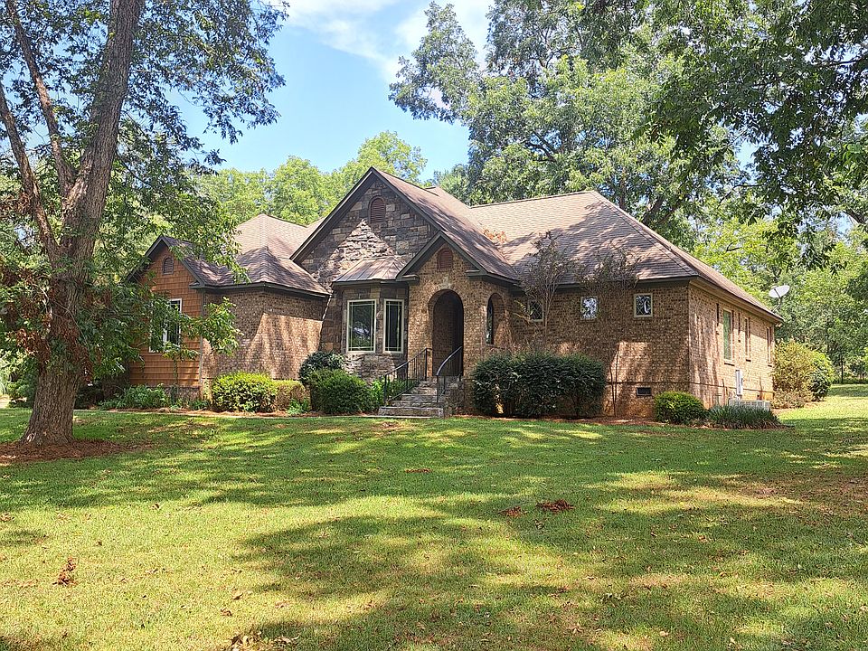 Exterior view of Arts and Crafts style home with primary construction materials of brick and stone