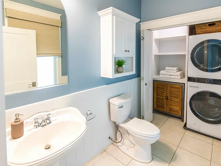 Downstairs powder room and laundry with stackable washer and dryer.