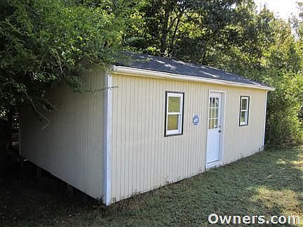 Front view of cabin at edge of woods